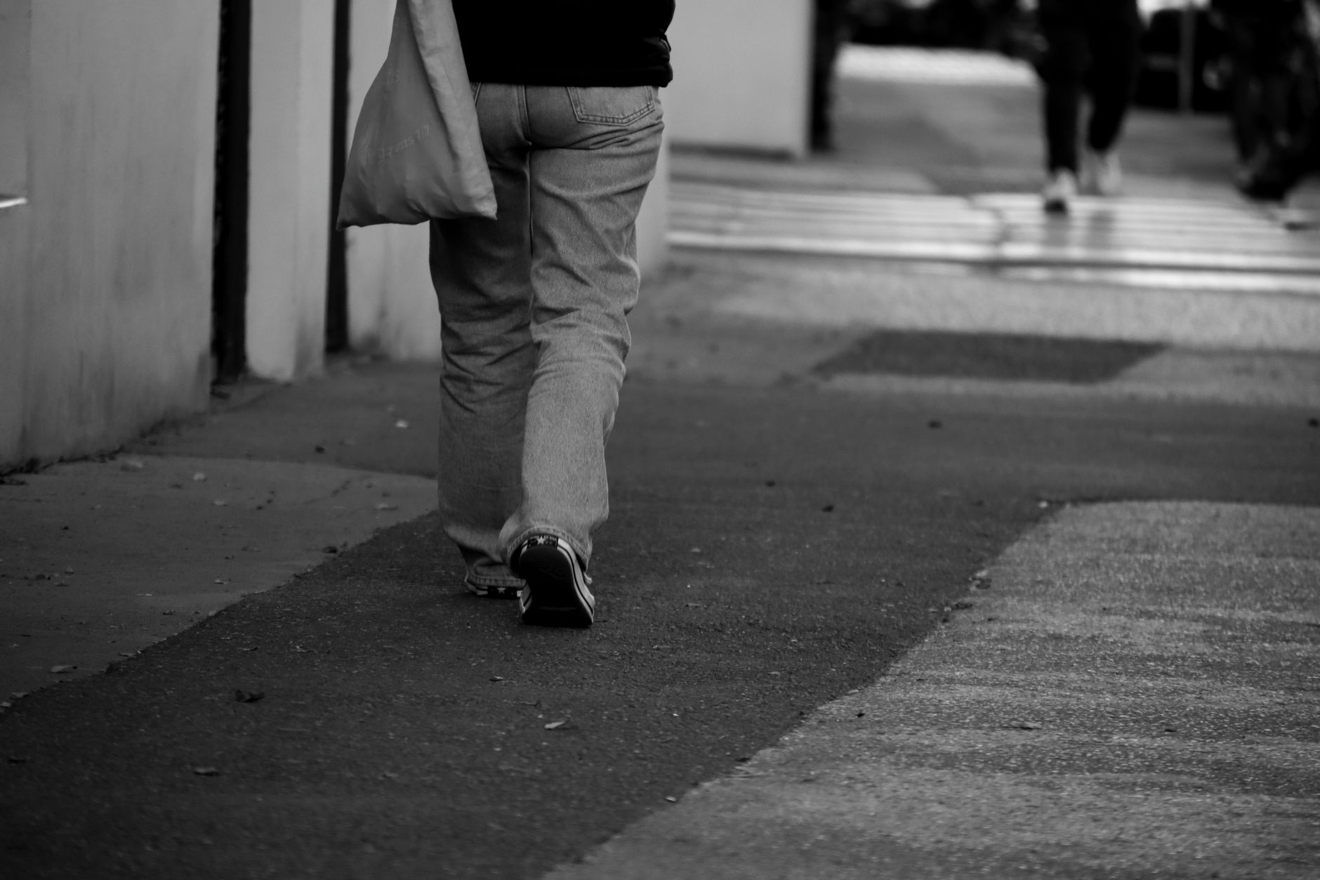 Une personne marche en extérieur, vue de dos