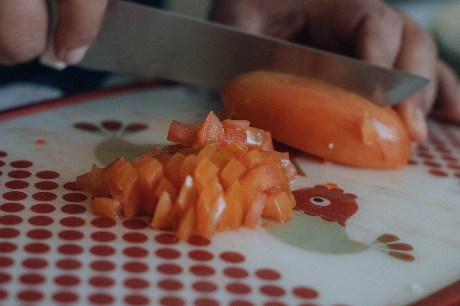 Des légumes en cours de découpe sur une planche de cuisine